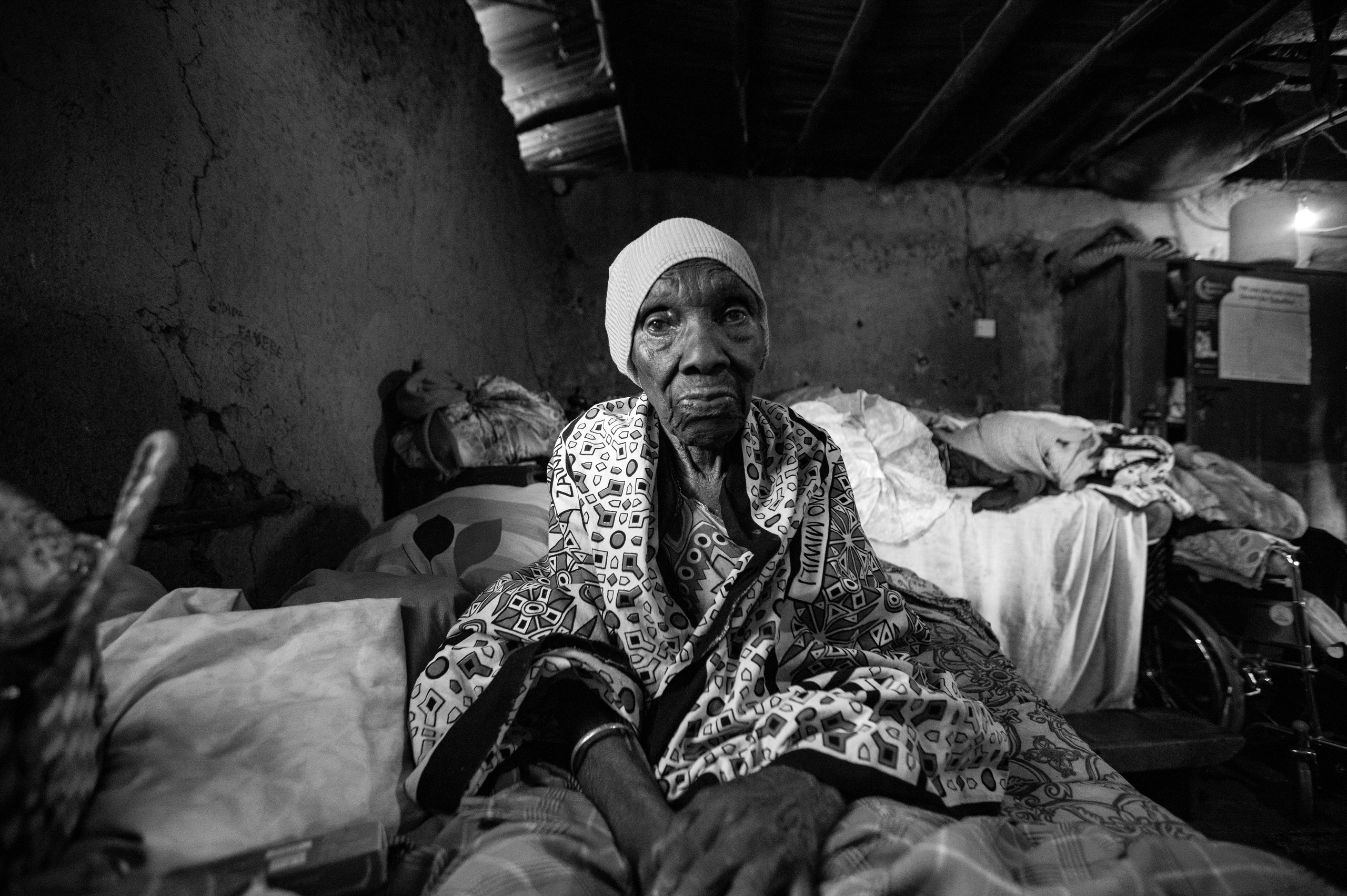 A 98 year old beneficiary of Kibera day centre for the elderly is photographed inside her house in Kibera resting on her bed during the Thursday volunteer home visits.